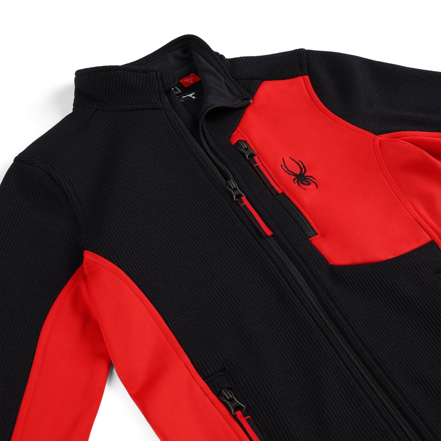 Close up of a black and red zippered collared jacket.