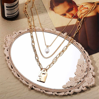 Pearl & Goldtone Embossed Face Pendant Necklace