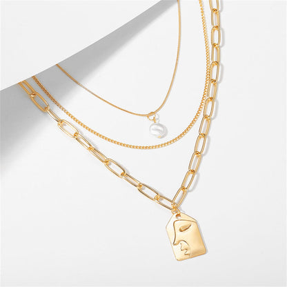 Pearl & Goldtone Embossed Face Pendant Necklace